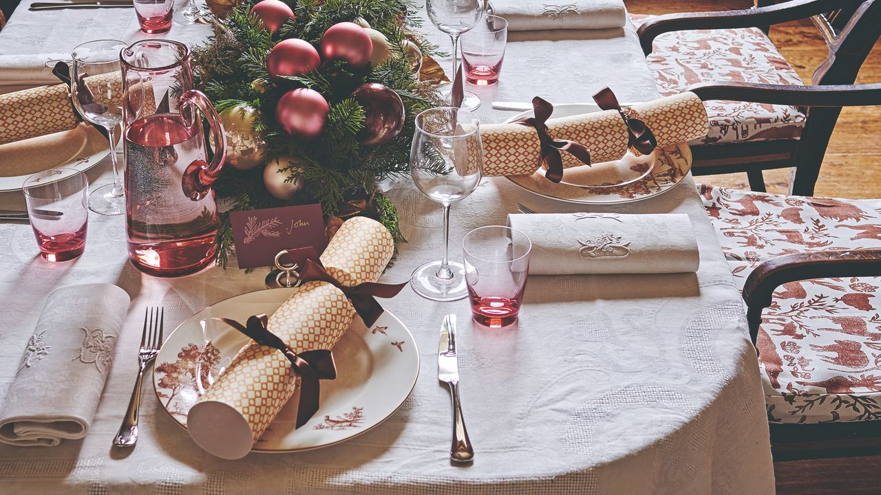 A decorated and set Christmas dining table with a centrepiece and Christmas crackers