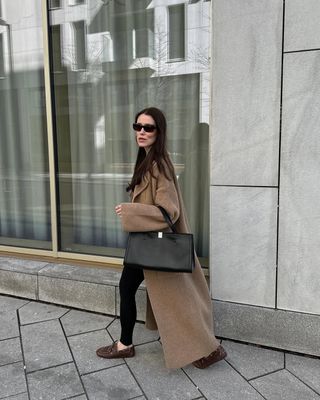 @annabelrosendahl wearing a long coat and leggings