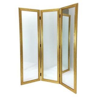 A freestanding gold folding mirror with three panels