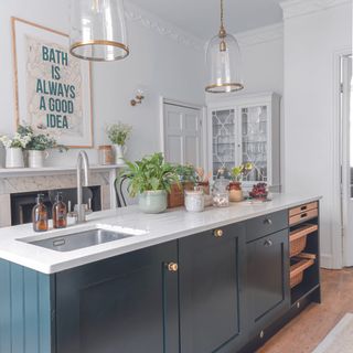Navy kitchen with island with a sink on it