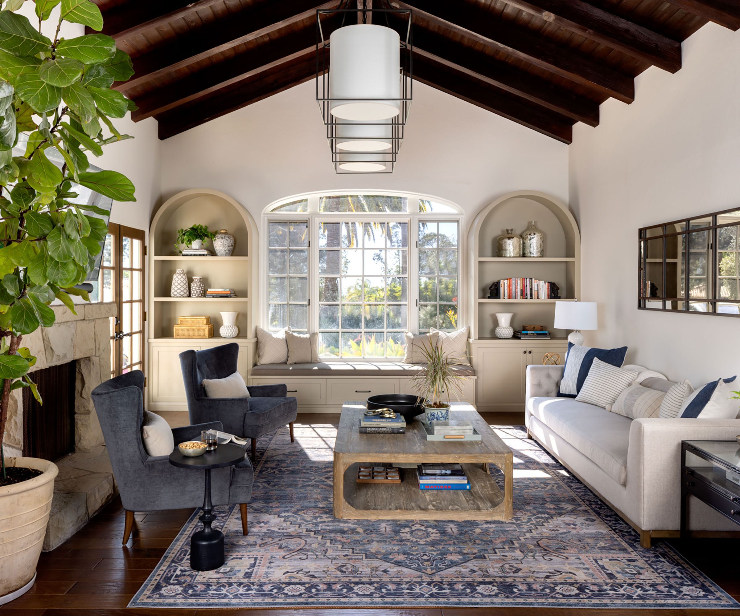 living room with dark wood ceiling and arched window and built-ins