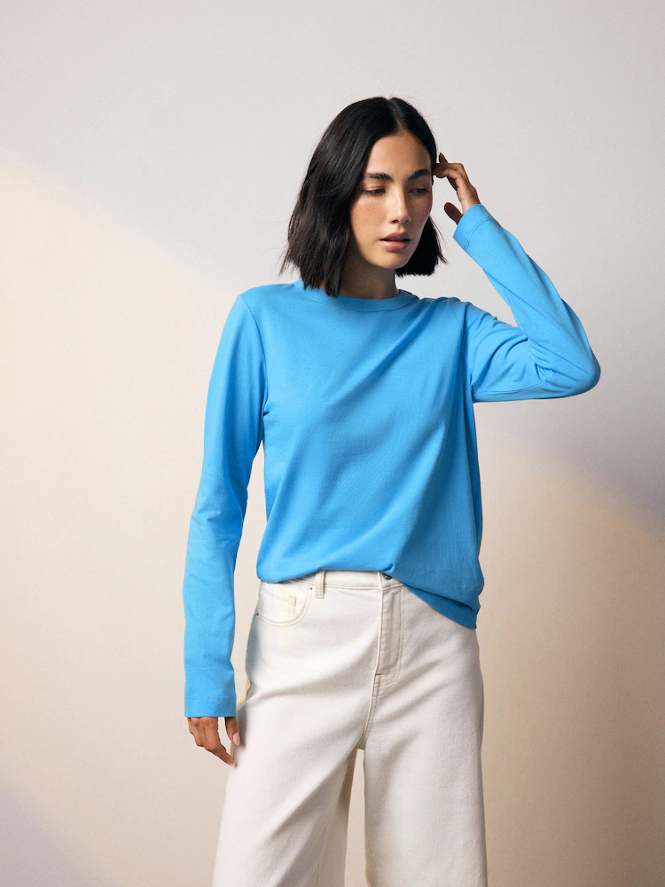 A model wears a turquoise Next long sleeve t-shirt.