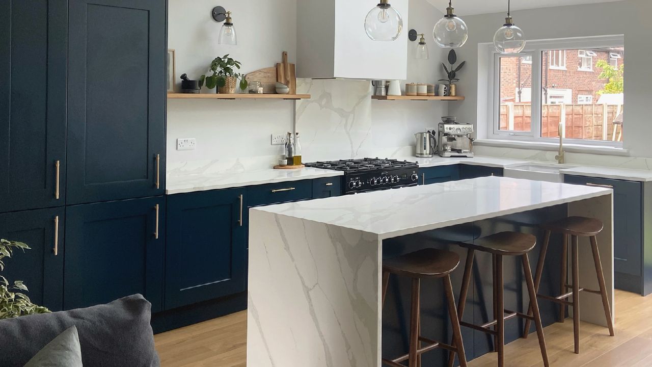 Navy kitchen with white marble waterfall island