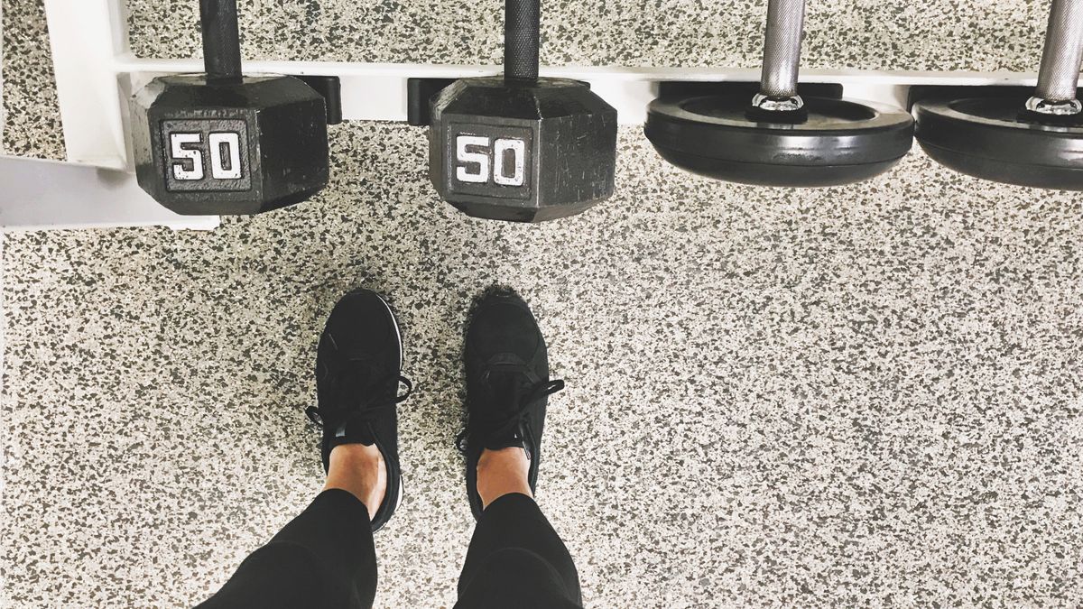 Feet standing in front of dumbbell rack