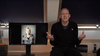 Photographer Harry Borden looking incredulous, sat in an office space with his photograph of Hillary Clinton on a monitor next to him