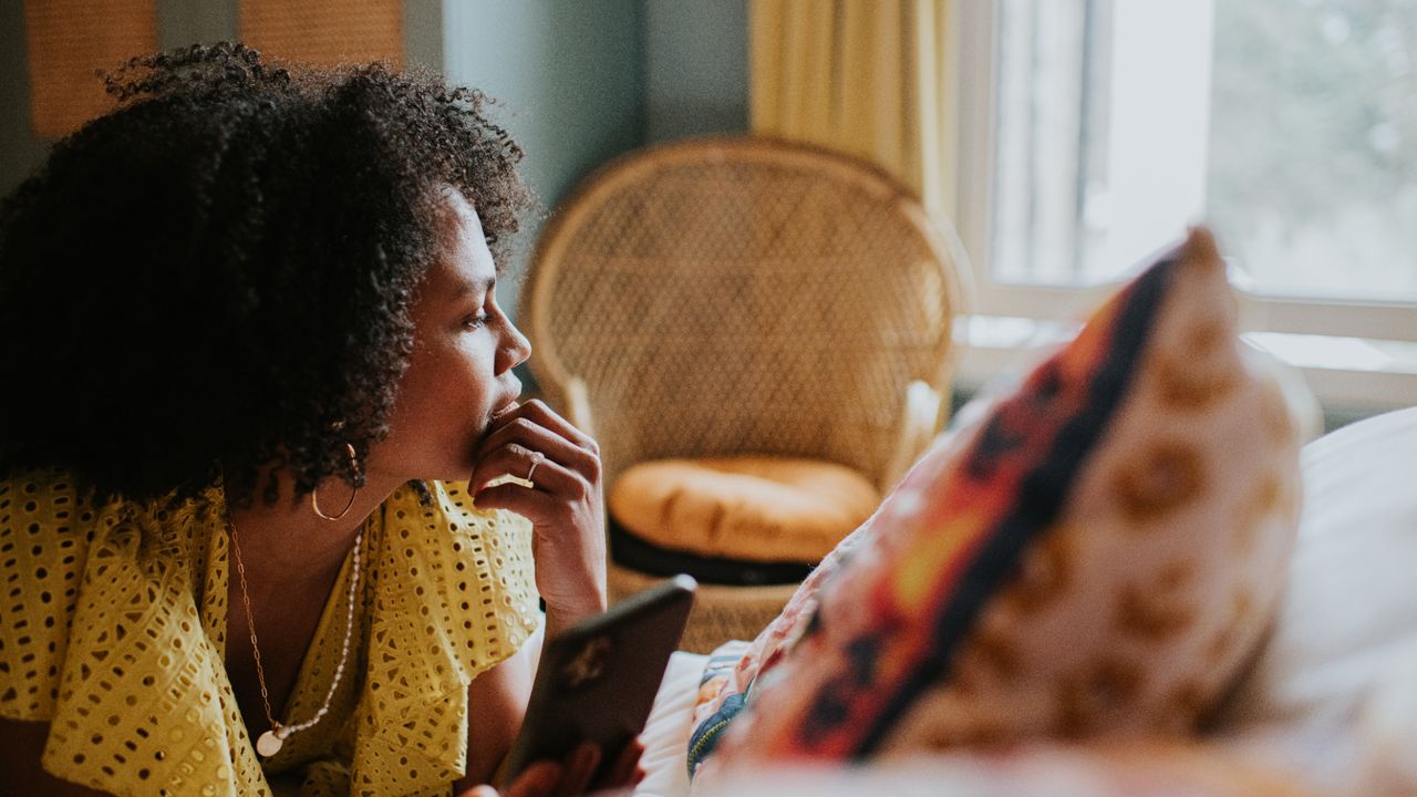 Woman sat indoors looking out of a window