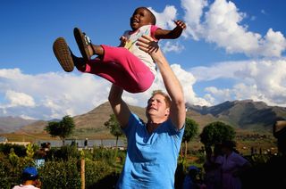 Prince Harry plays with a three-year-old blind girl called Karabo during a visit to Phelisanong childrens’ home on December 6 2014 in Pitseng, Lesotho