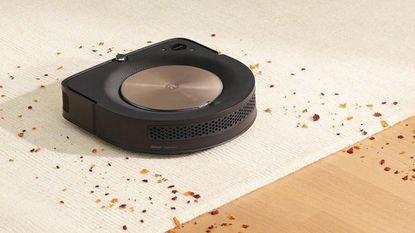 An iRobot Roomba s9+ clearing debris on a carpet and a hardwood floor