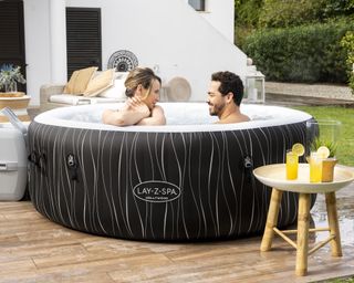 two people sitting in a hot tub on a patio
