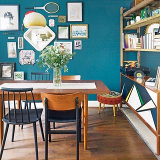 blue wall with wooden table and chairs