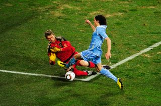 Germany goalkeeper Hans-Jorg Butt dives at the feet of Uruguay's Edinson Cavani in the 2010 World Cup third place match.