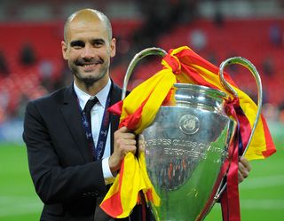 Barcelona's Spanish coach Josep Guardiola celebrates with the trophy at the end of the UEFA Champions League final football match FC Barcelona vs. Manchester United, on May 28, 2011 at Wembley stadium in London.Barcelona won 3 to 1.