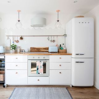 A white kitchen with a white Smeg fridge