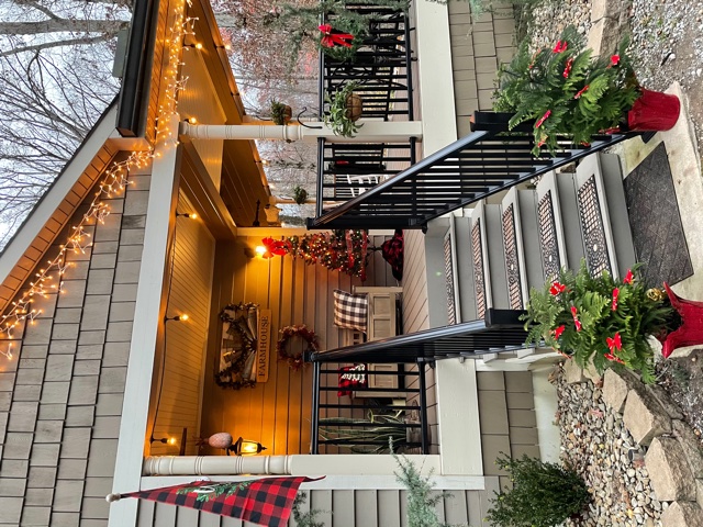 A porch with seating decorated for Christmas