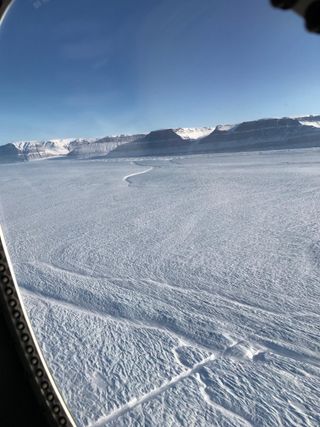A portion of the new rift at the center of Petermann Glacier's floating ice shelf (straight feature near bottom center), and an older rift from the side of the shelf (near top center), as photographed during a recent Operation IceBridge mission in northeast Greenland.