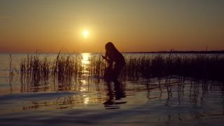 A young Kya standing in the marsh in the Where the Crawdads Sing trailer