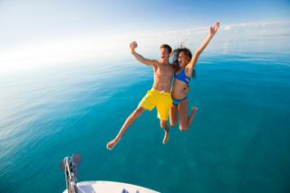 A couple jumping into the sea on Nassau Paradise Island