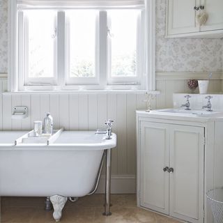 bathroom with tiles floor with white bathtub