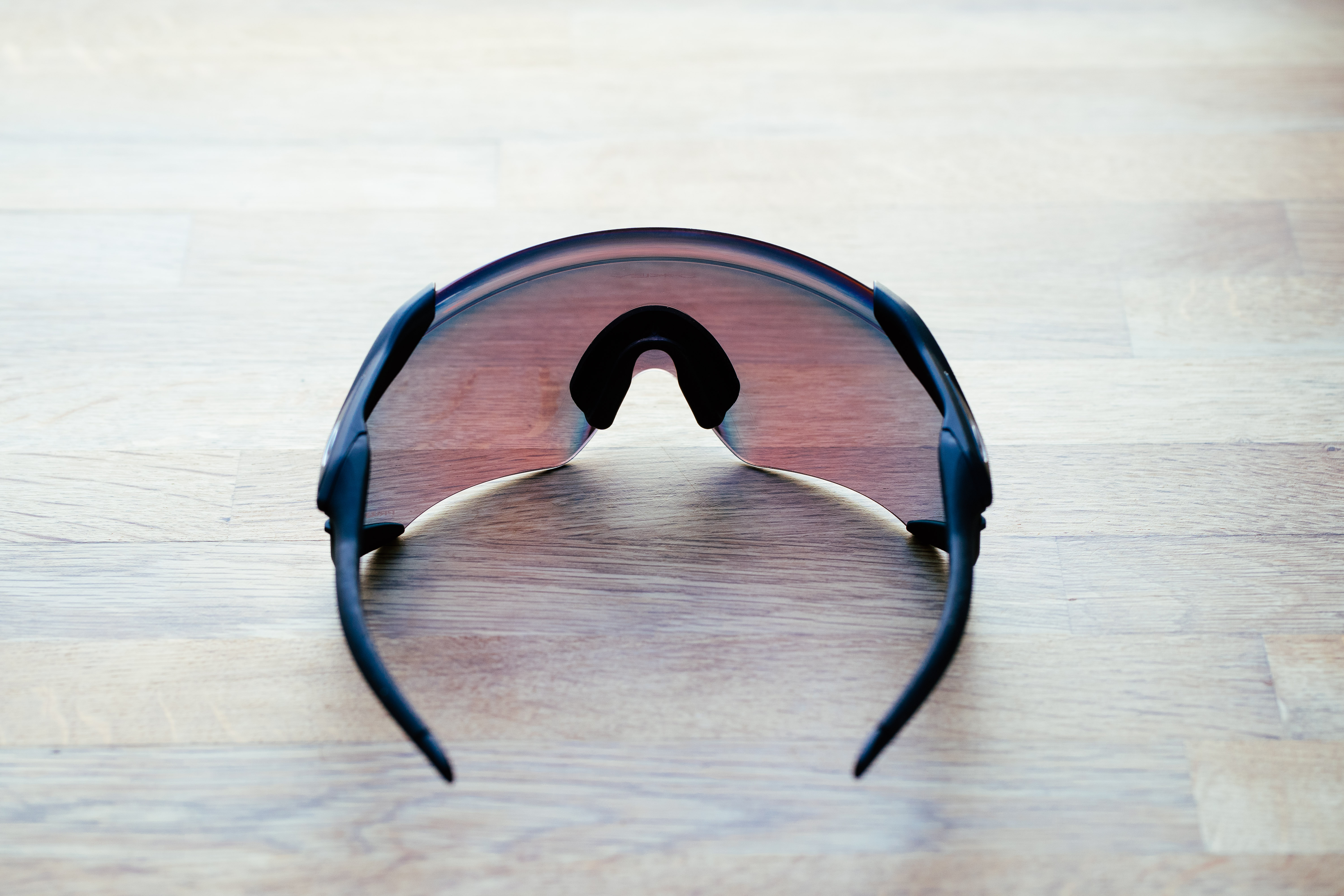 A set of large wraparound sports glasses on a wooden surface
