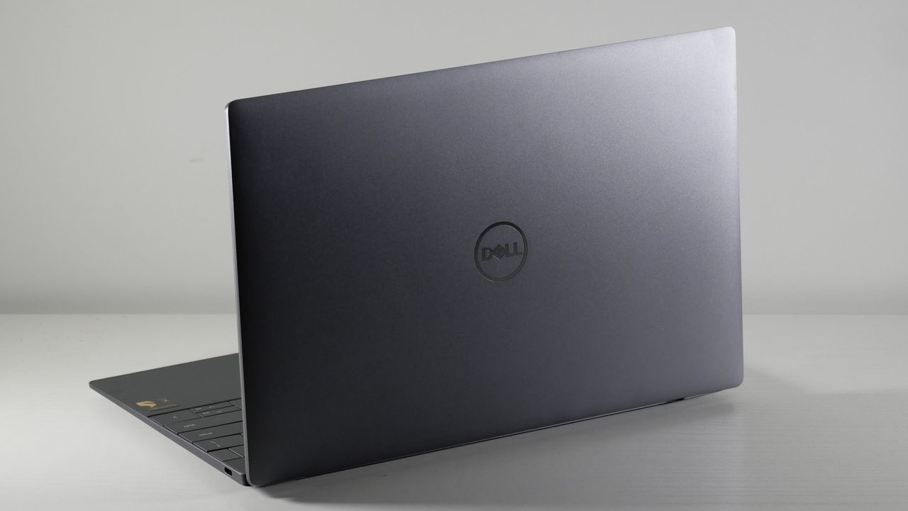 Dell XPS 13 9345 (Snapdragon X Elite) open on a white desk angled away from camera showing the lid.