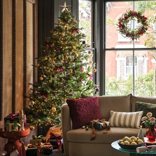 living room with christmas tree and sofa with cushions on