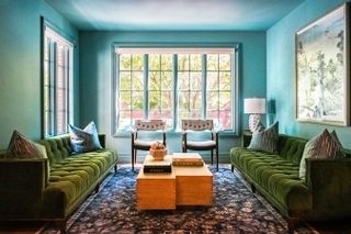 a blue living room with green sofa