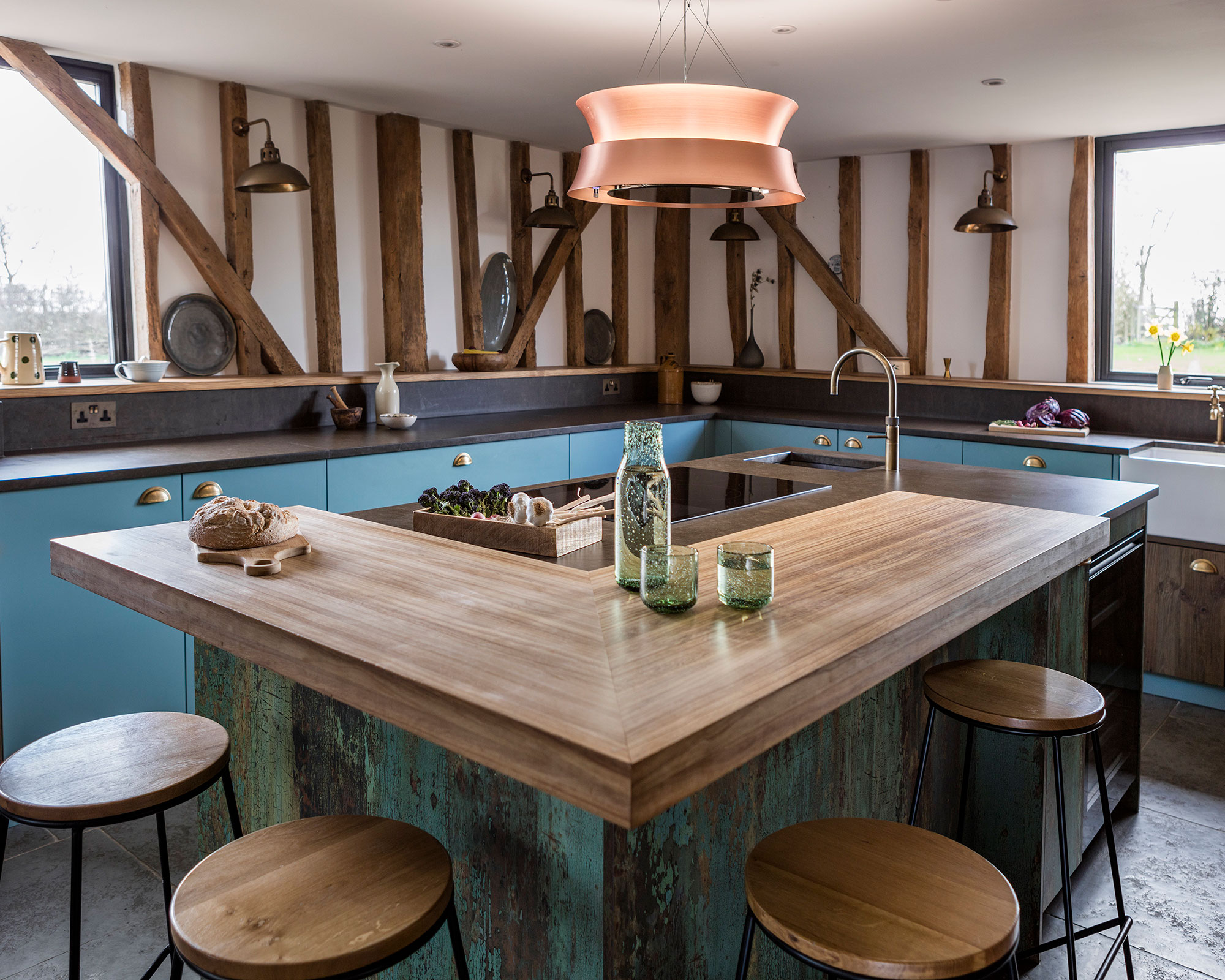 L shaped kitchen island ideas in a blue and wood scheme with beamed walls.