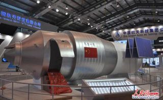 Display model of Tiangong I module at an exhibition hall at the China Academy of Space Technology, complete with access door for public viewing.