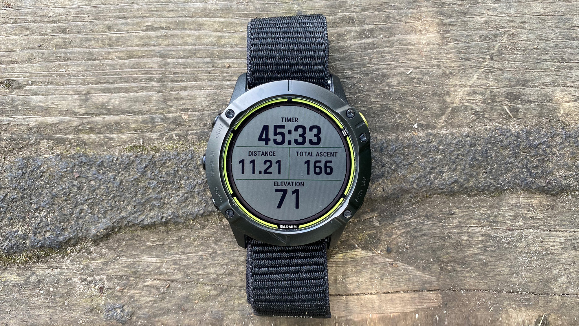 The Garmin Enduro running watch pictured on a slab of wood