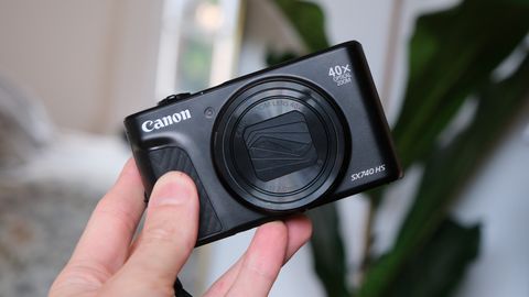 Canon PowerShot SX740 HS compact camera held in a hand