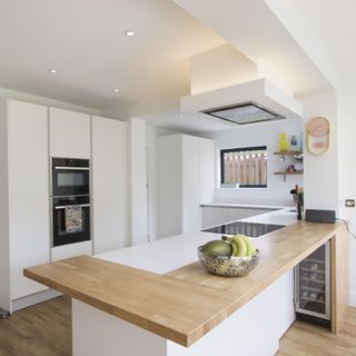 kitchen with white walls wooden flooring and wooden countertop