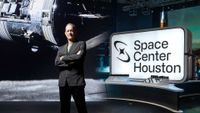 photo of a man wearing a suit standing next to a sign that says "space center houston"