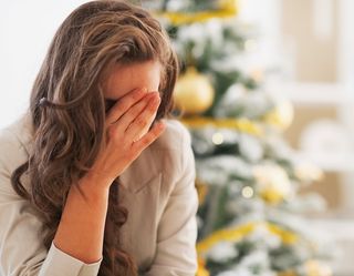depressed woman by a christmas tree