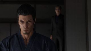 A screenshot of Kiryu being approached by a shadowy figure