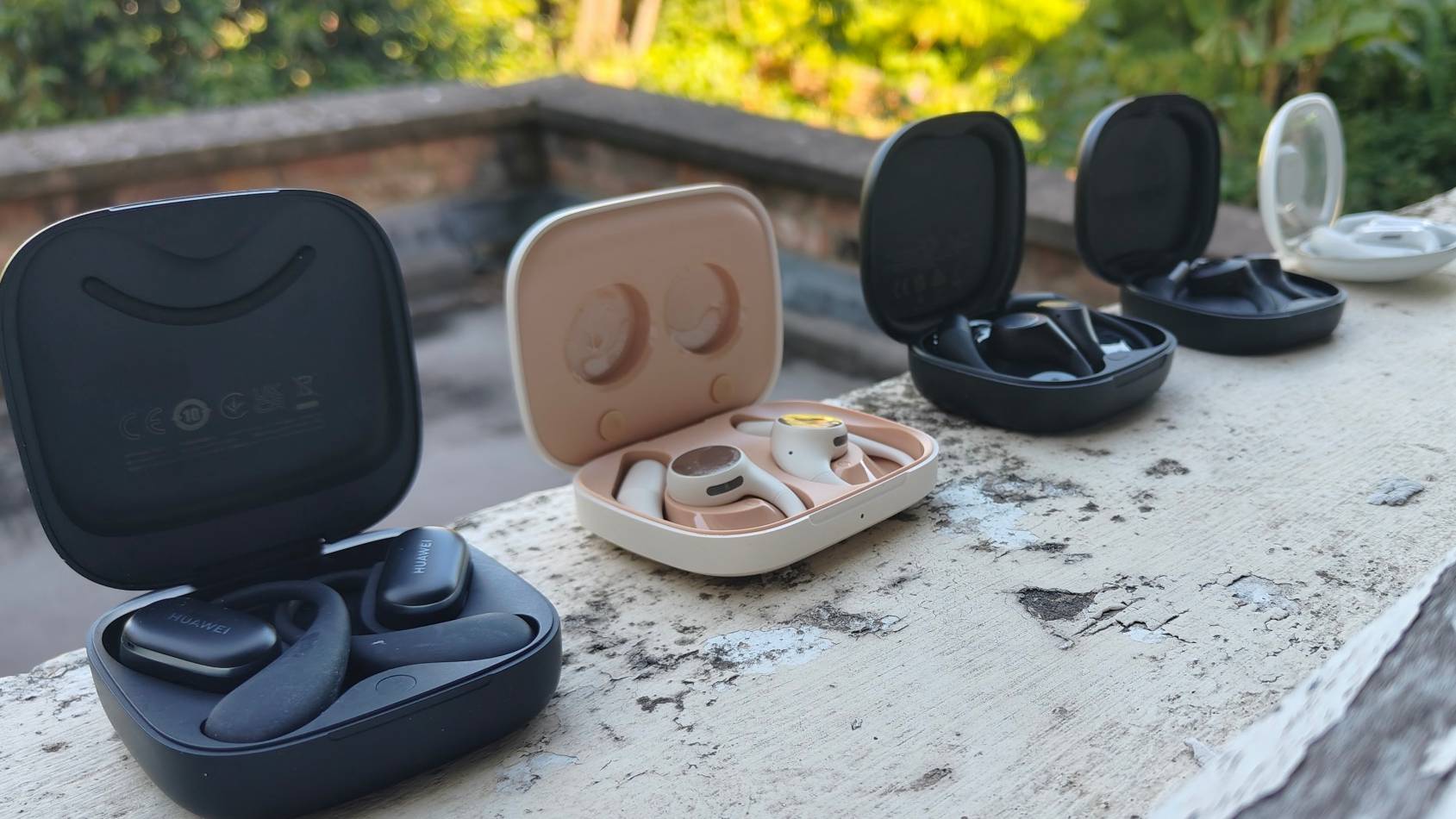 Several pairs of open earbuds lined up on a window ledge.