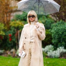 women wearing a trench coat while holding an umbrella 