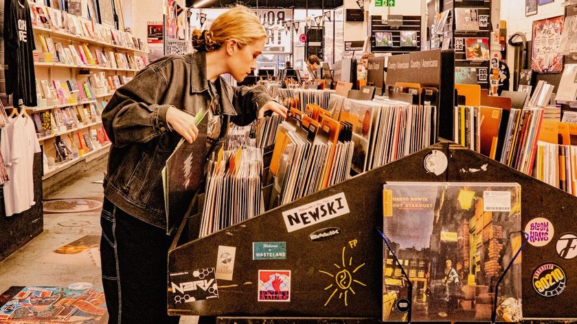 A woman flicking through stacks of vinyl records in a Rough Trade shop.