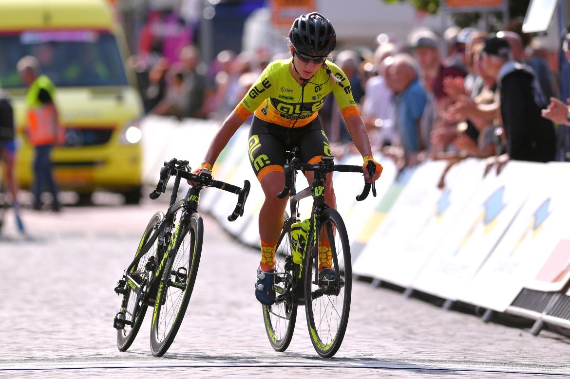 Karlijn Swinkels pulls her teammate's bike across the line
