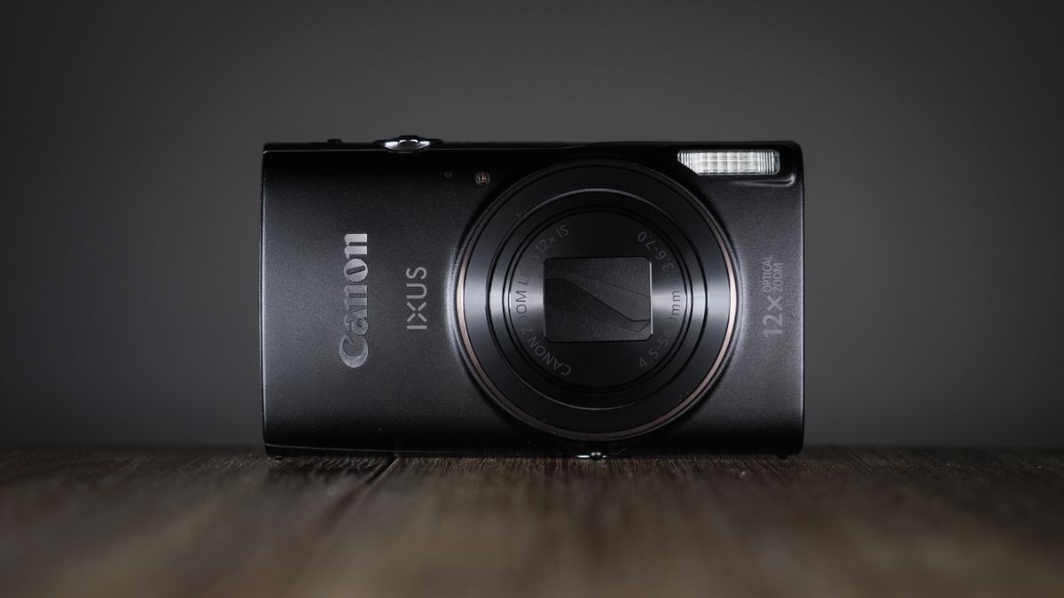Canon Ixus 285 HS A on a wooden surface against a dark background