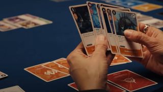 A screenshot of someone holding a hand of Project K cards in the reveal video for Riot Games' new TCG.