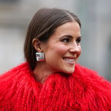 street style shot of woman wearing red furry coat