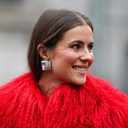 street style shot of woman wearing red furry coat