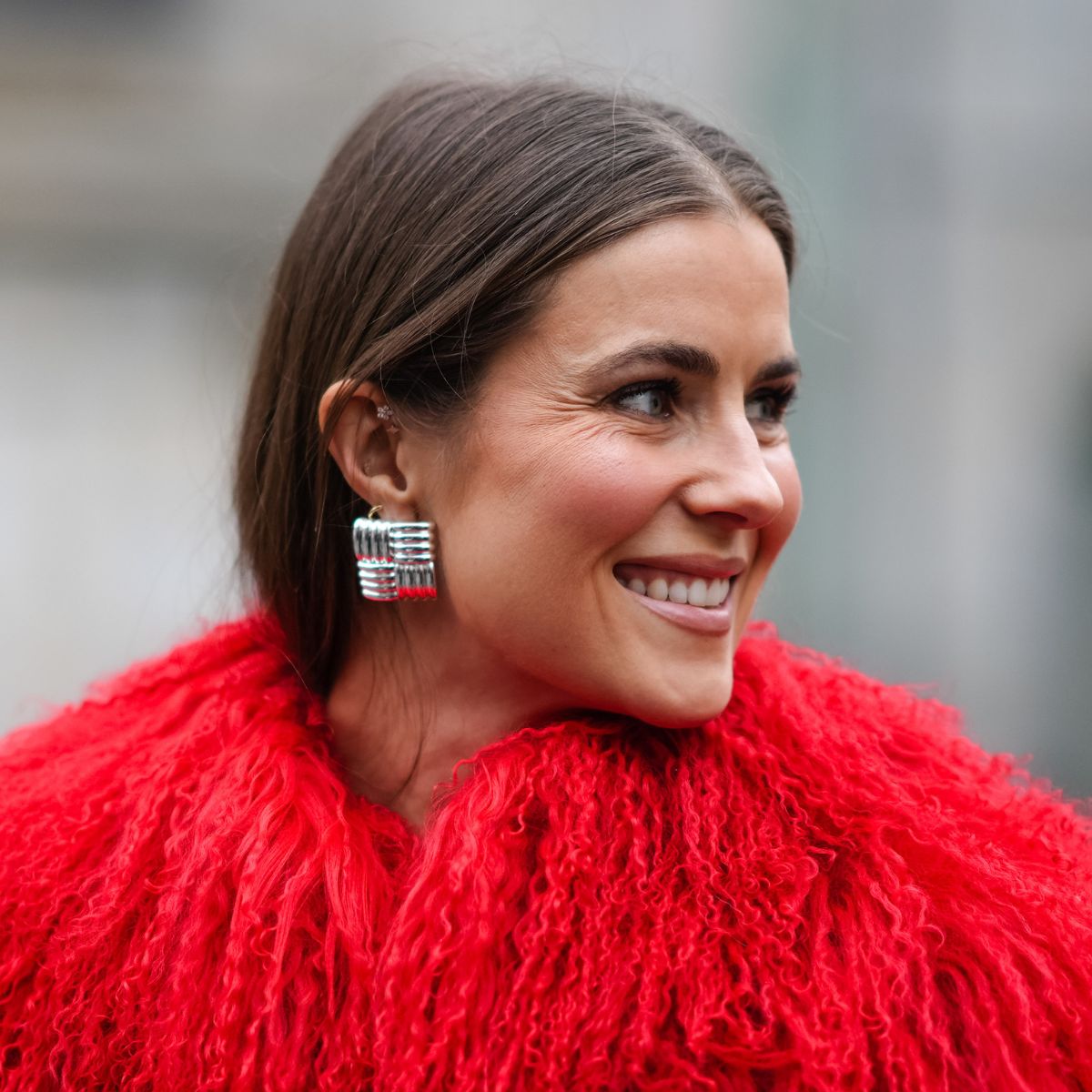 street style shot of woman wearing red furry coat