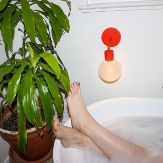 Person in bath tub with a Poplight on the wall