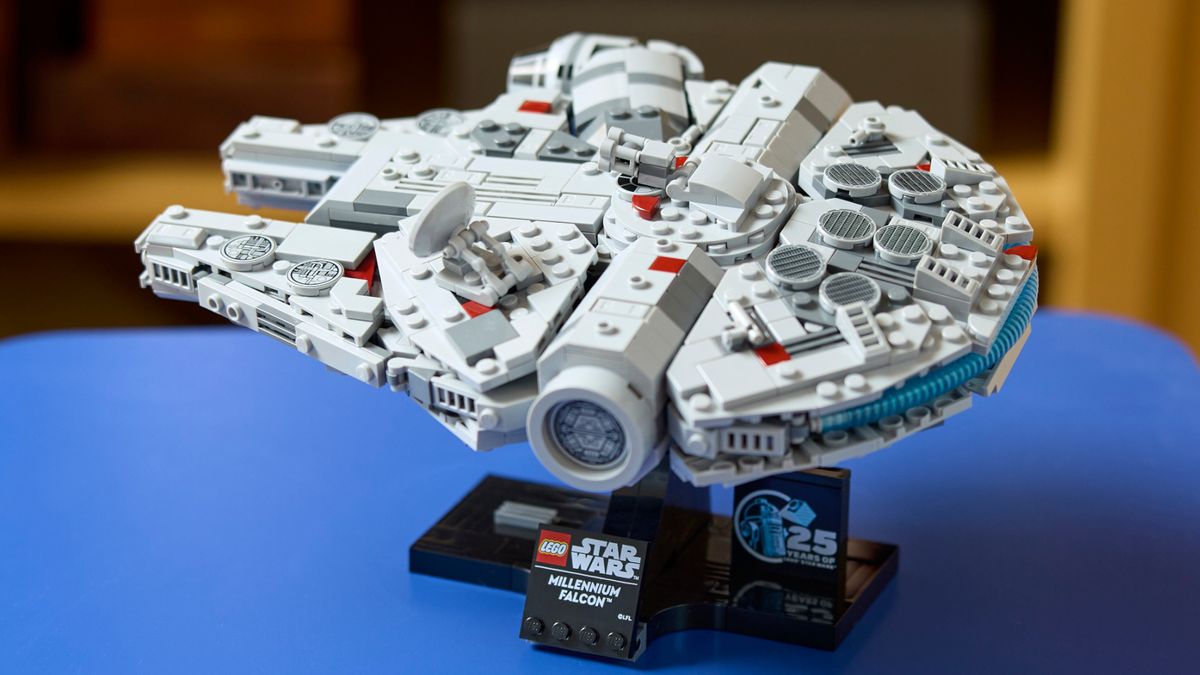 Lego Millennium Falcon model on its stand on a blue table
