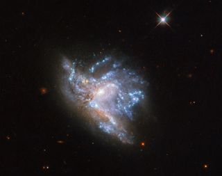 A Hubble Space Telescope image shows an object known as NGC 6052, which is made up of two relatively-nearby galaxies colliding just 230 million light years away.