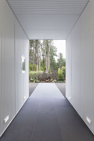 A covered passageway links the main house with the garage, leading to the property's back garden