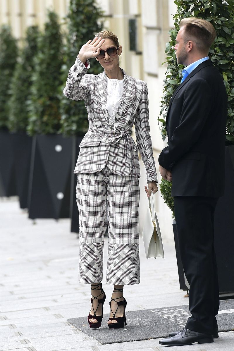 In an Antonio Berardi plaid pantsuit, red velvet platform heels, oversized sunglasses and a white bag out in Paris.