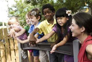 A group of young children plays with bubbles.