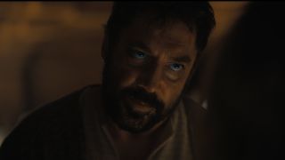 Image from the sci-fi movie Dune. Close up of a man's face. He has short dark hair and a full beard. He is looking intently at someone standing in front of him.